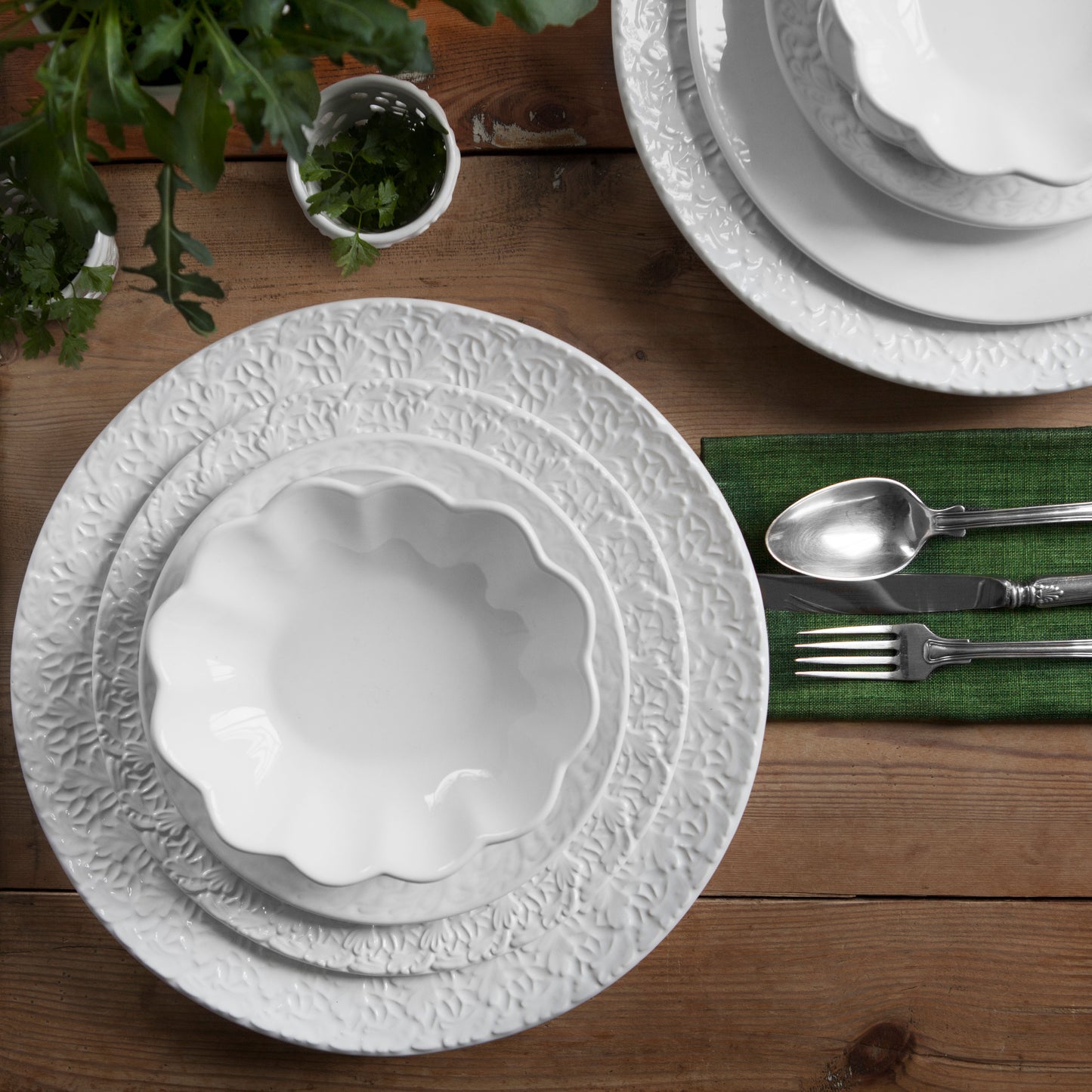 White textured plate on a wooden table with silverware and green placemat