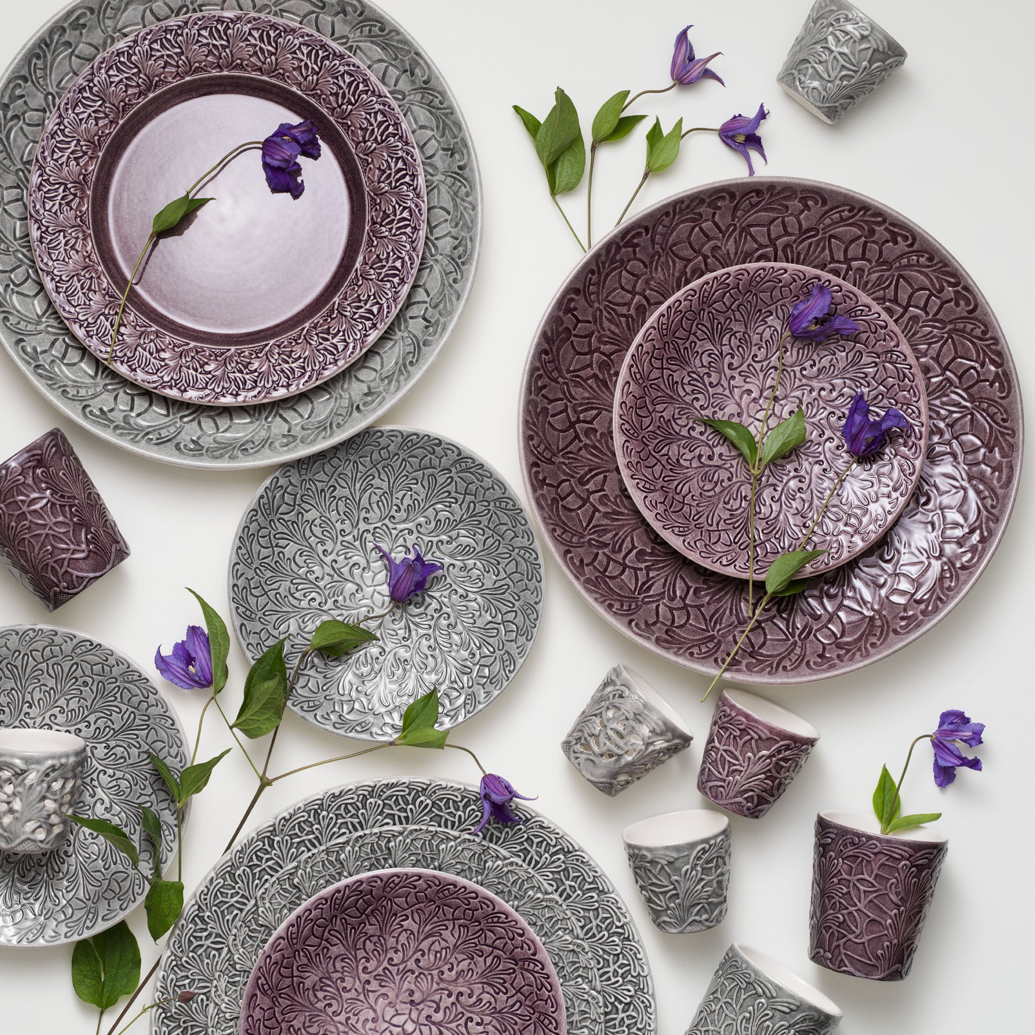 Decorative ceramic plates and cups with intricate patterns on a white background.