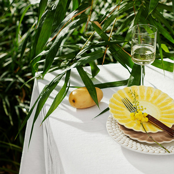 Table setting with a dessert, glass of wine, and mango against a natural background