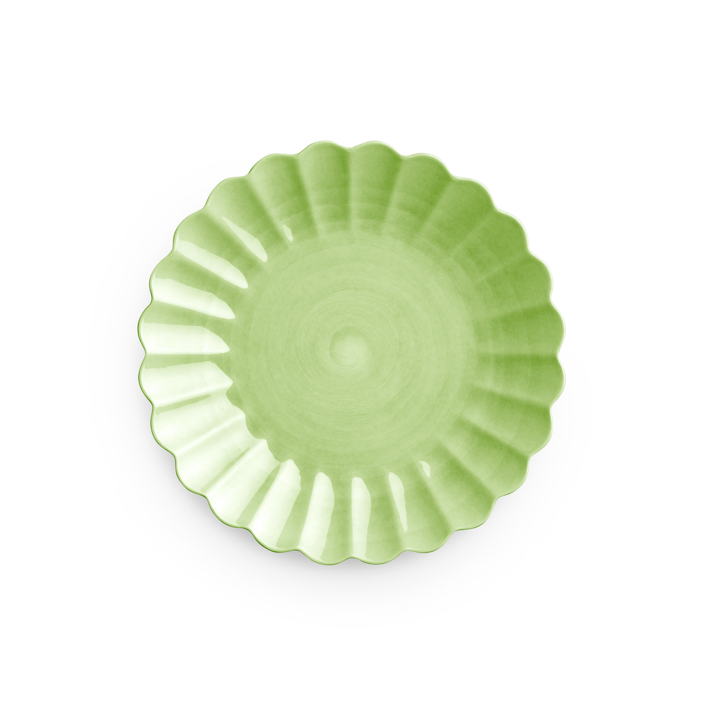 Green ceramic plate with scalloped edge on a white background