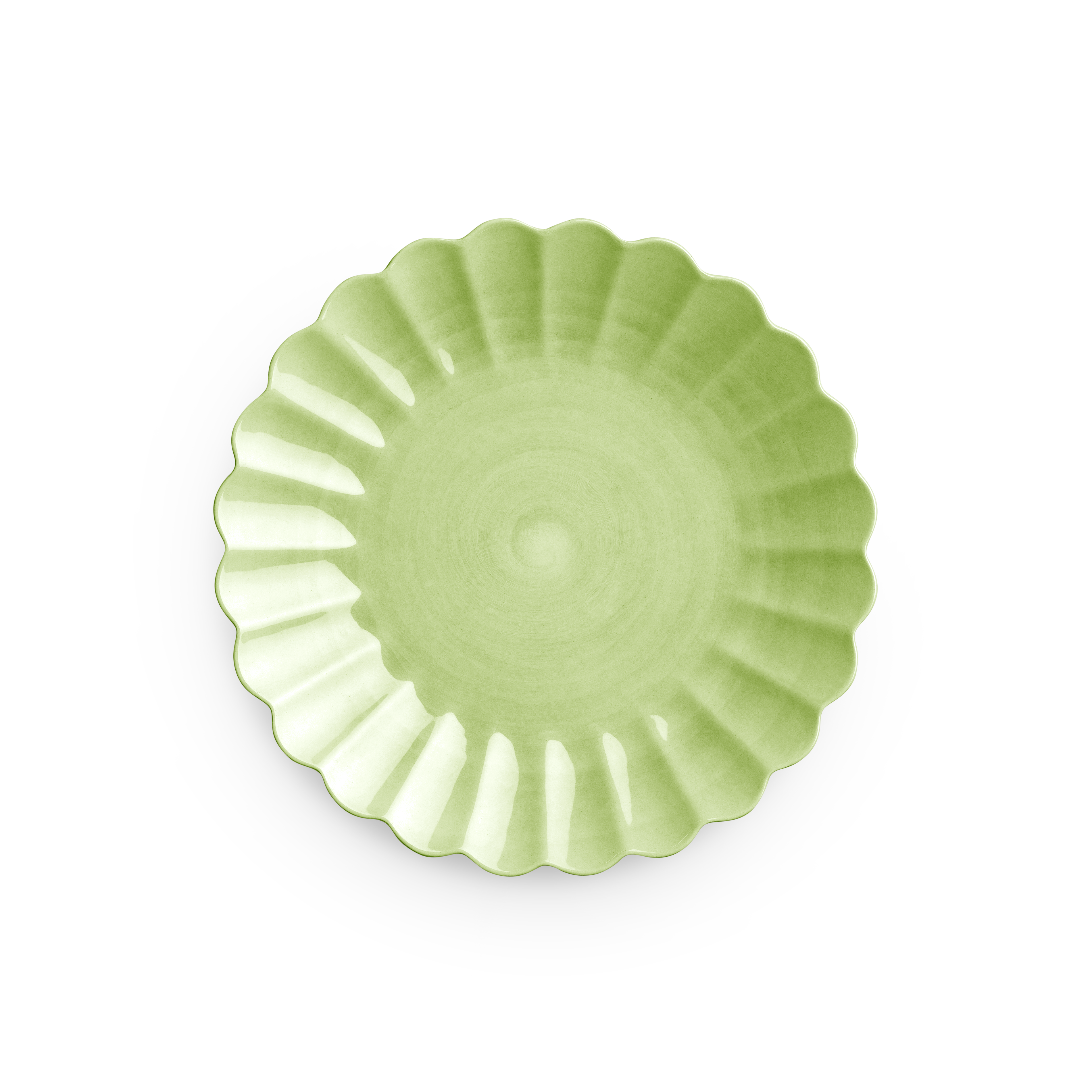 Green ceramic plate with scalloped edge on a white background