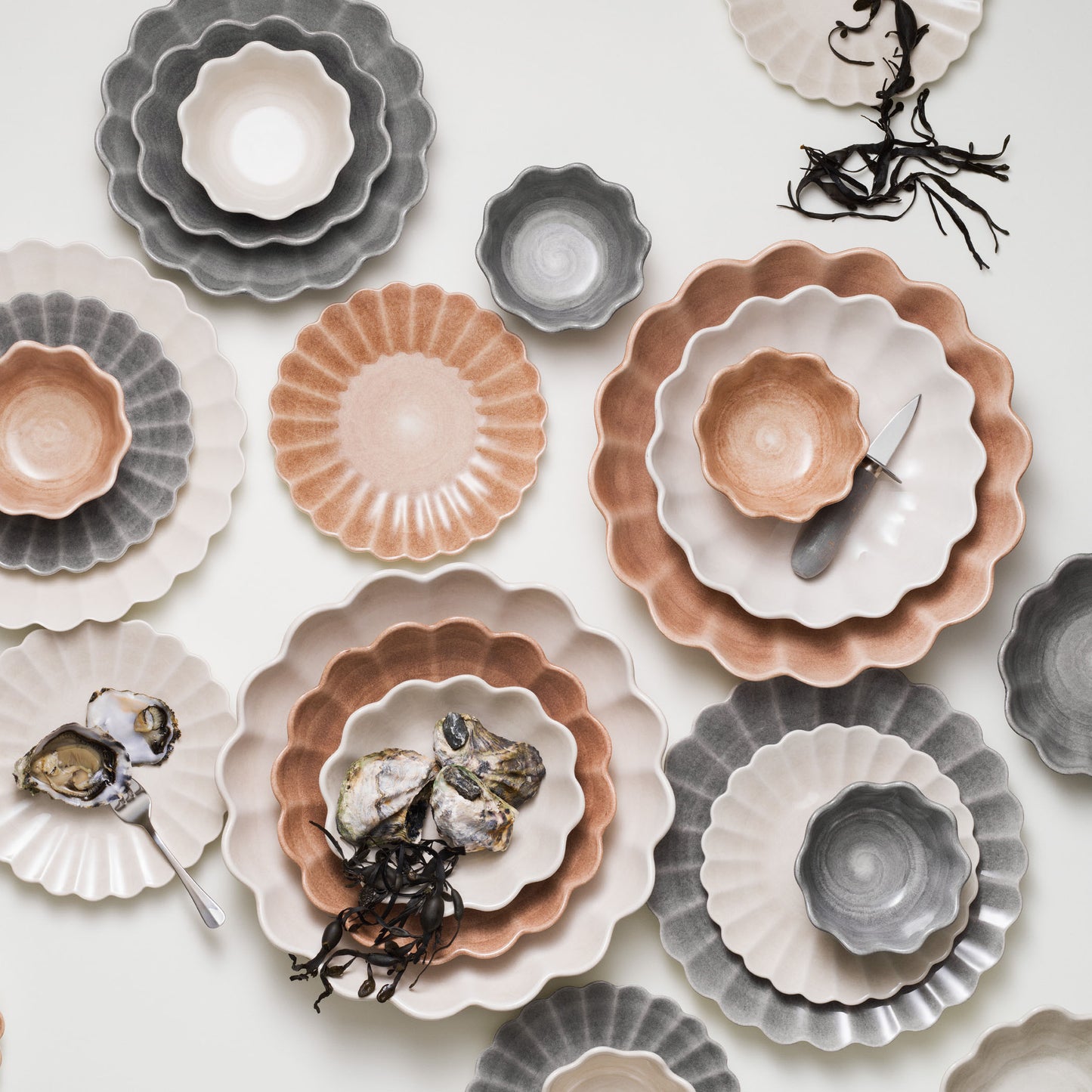 Collection of ceramic plates and bowls in various colors on a white background