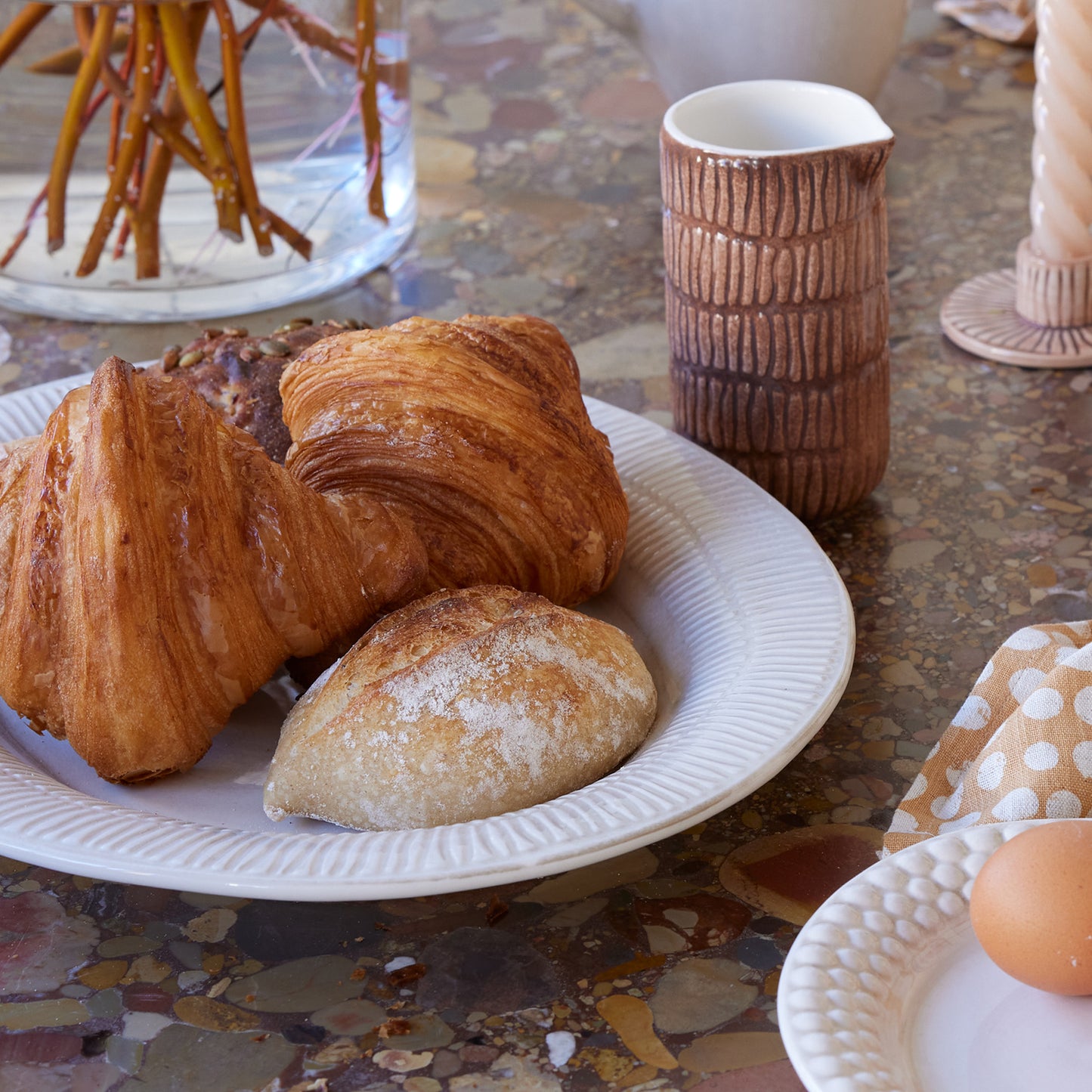 Baked goods on a plate with a textured mug in the background