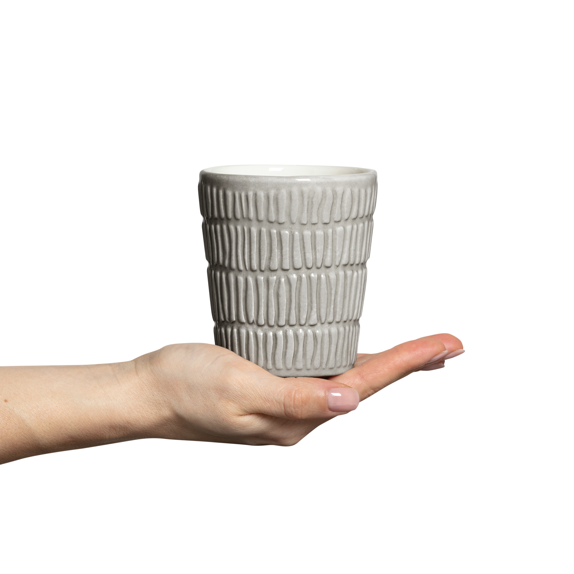 Hand holding a textured ceramic cup against a white background