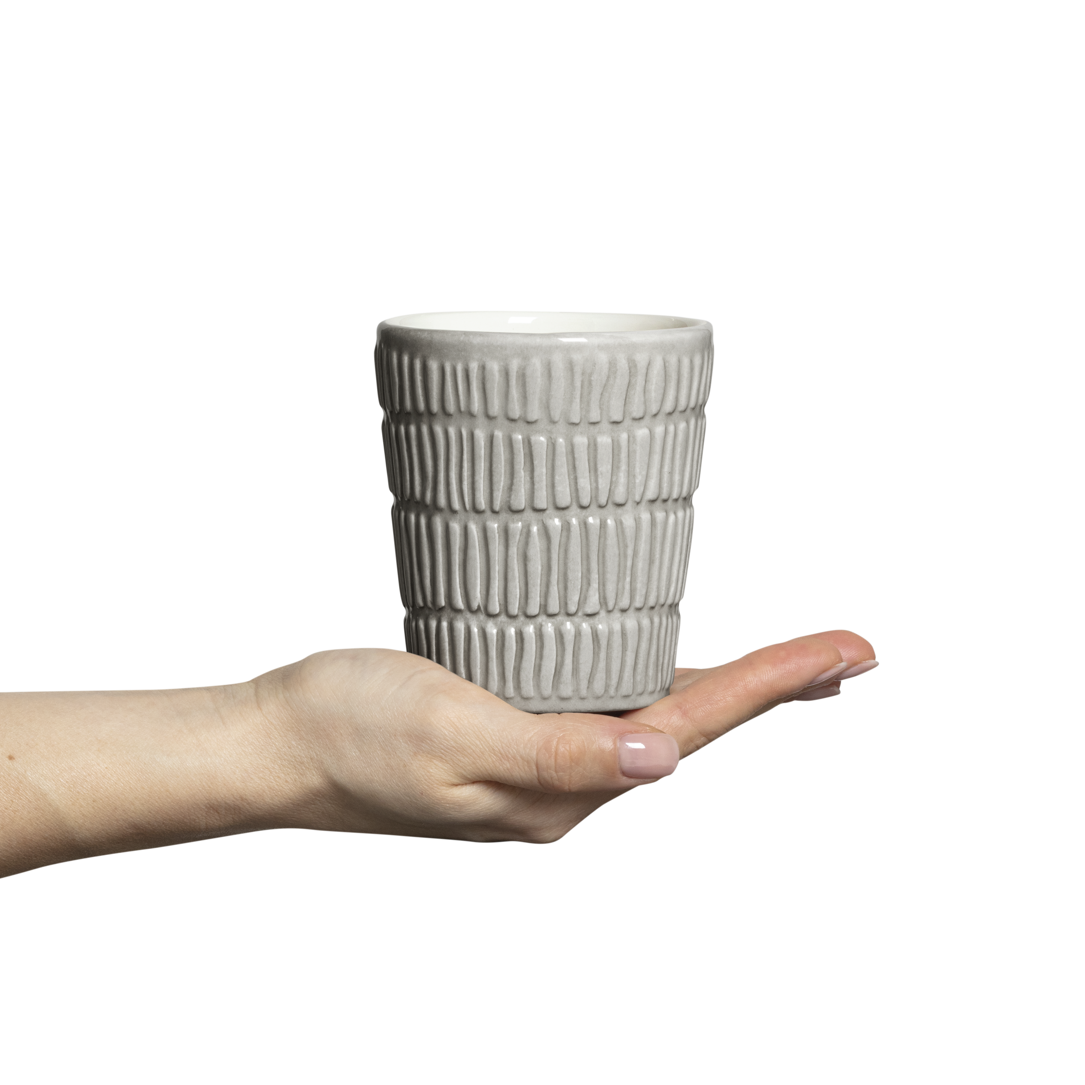 Hand holding a textured ceramic cup against a white background