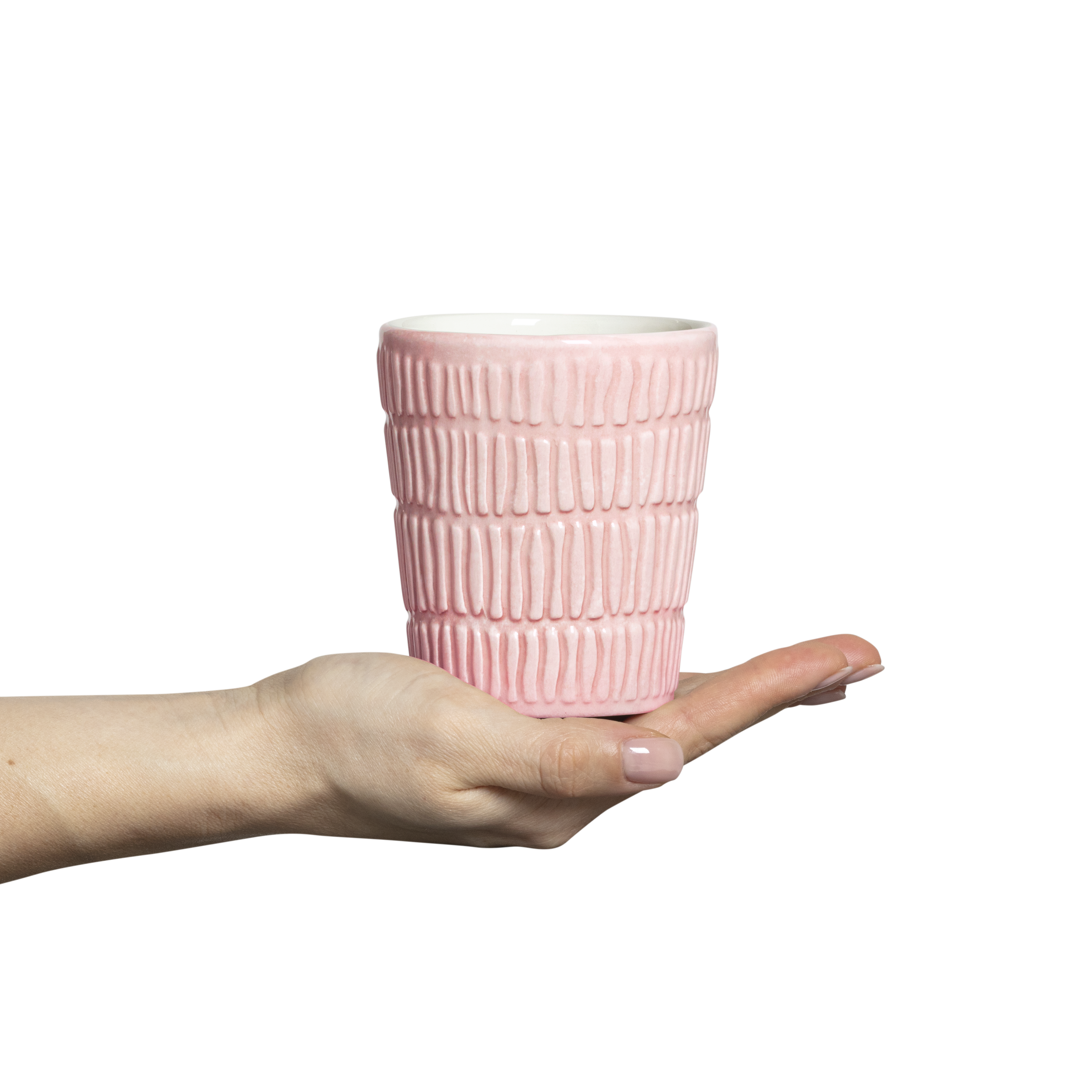 Pink textured ceramic cup held in a hand against a white background