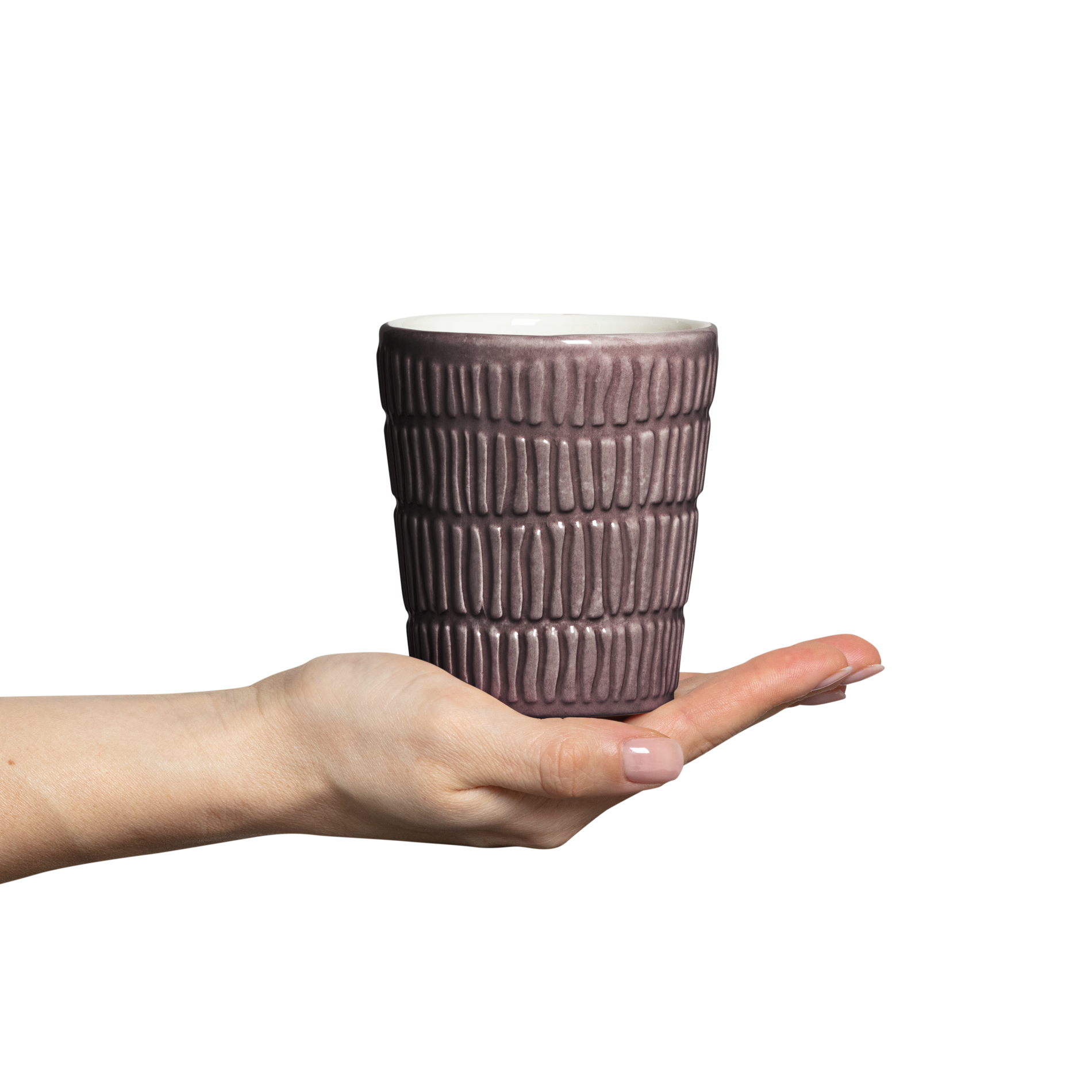 Hand holding a textured ceramic cup against a white background