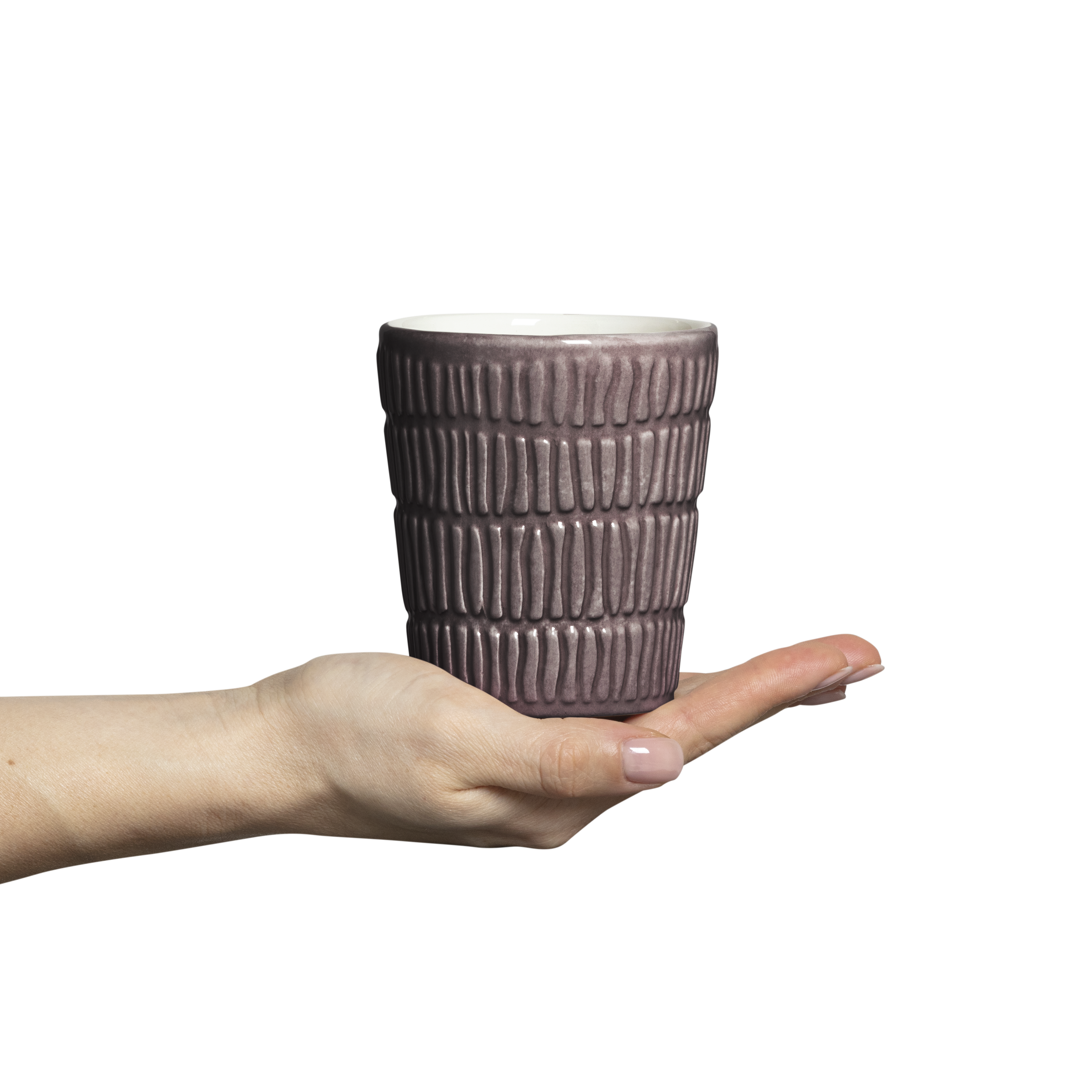 Hand holding a textured ceramic cup against a white background