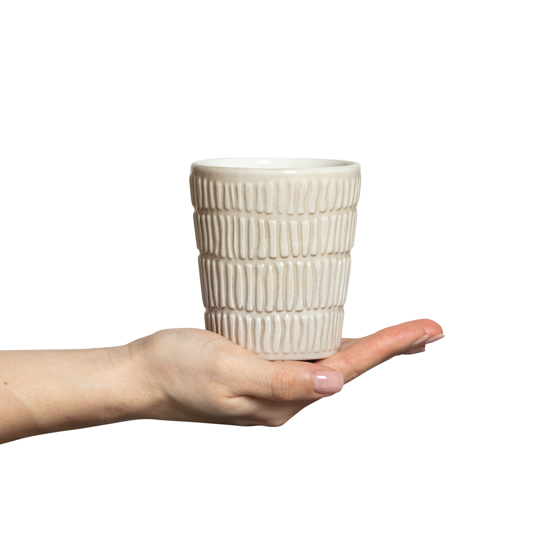 Hand holding a textured ceramic cup against a white background