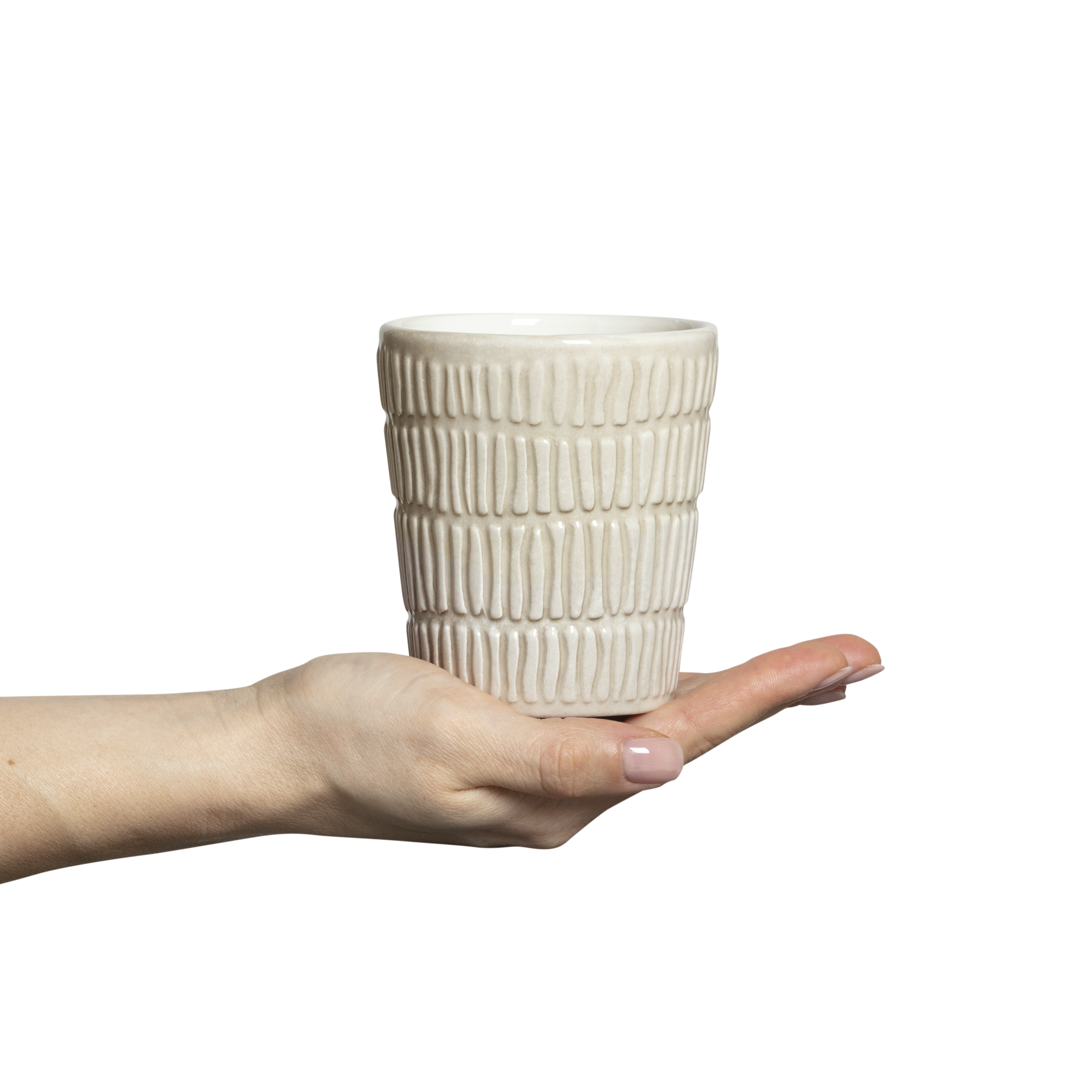 Hand holding a textured ceramic cup against a white background