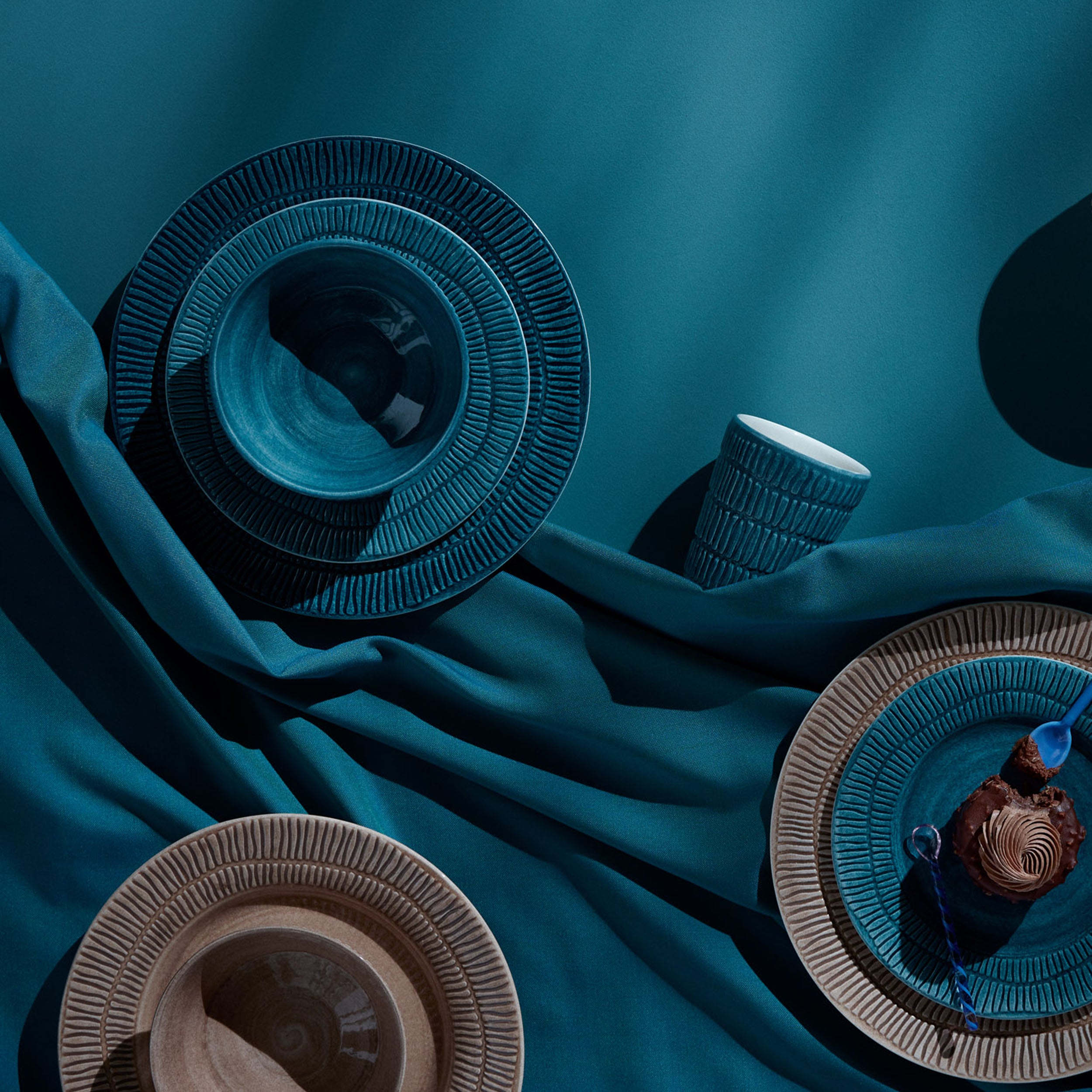 Decorative bowls on a teal fabric background