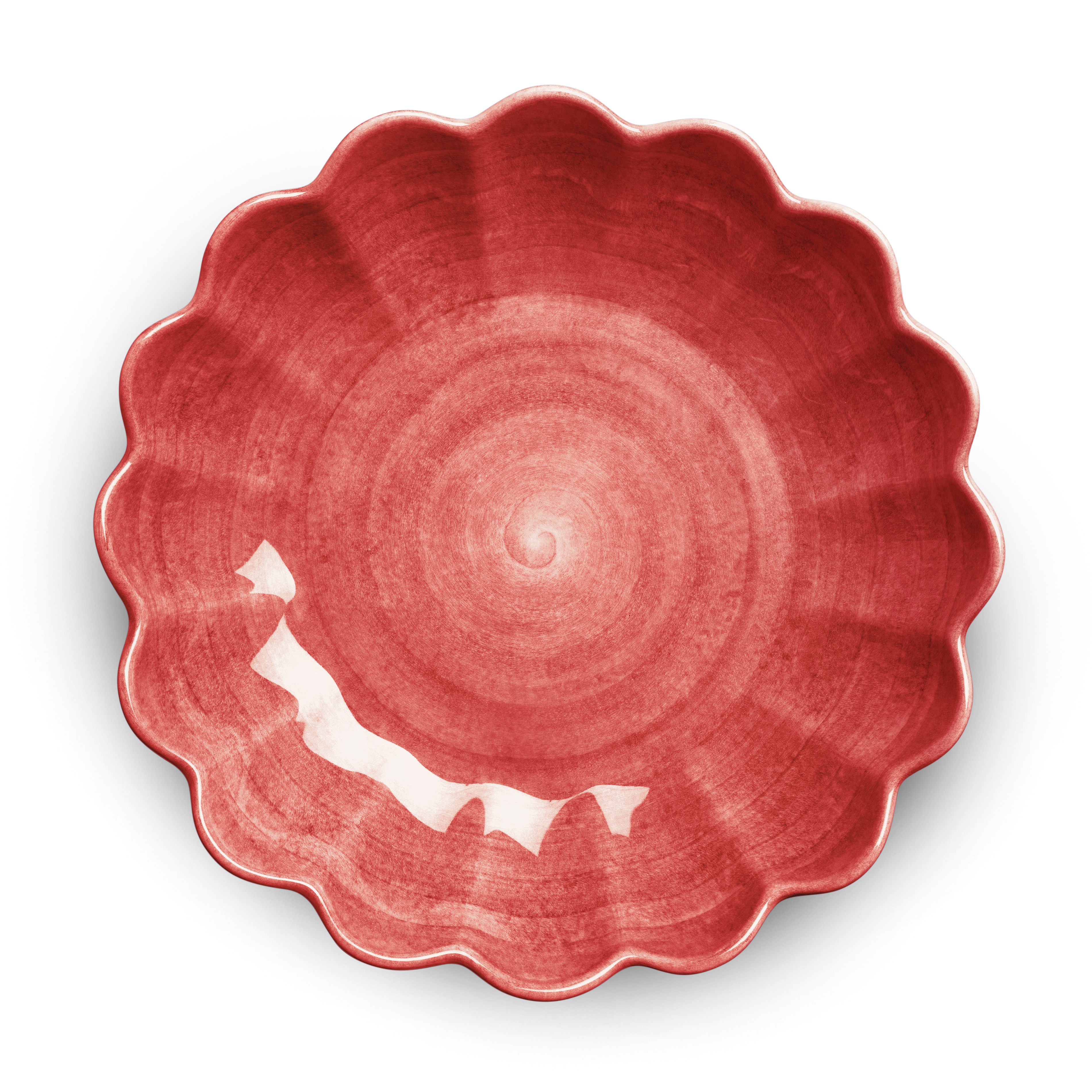 Red ceramic plate with scalloped edge on a white background