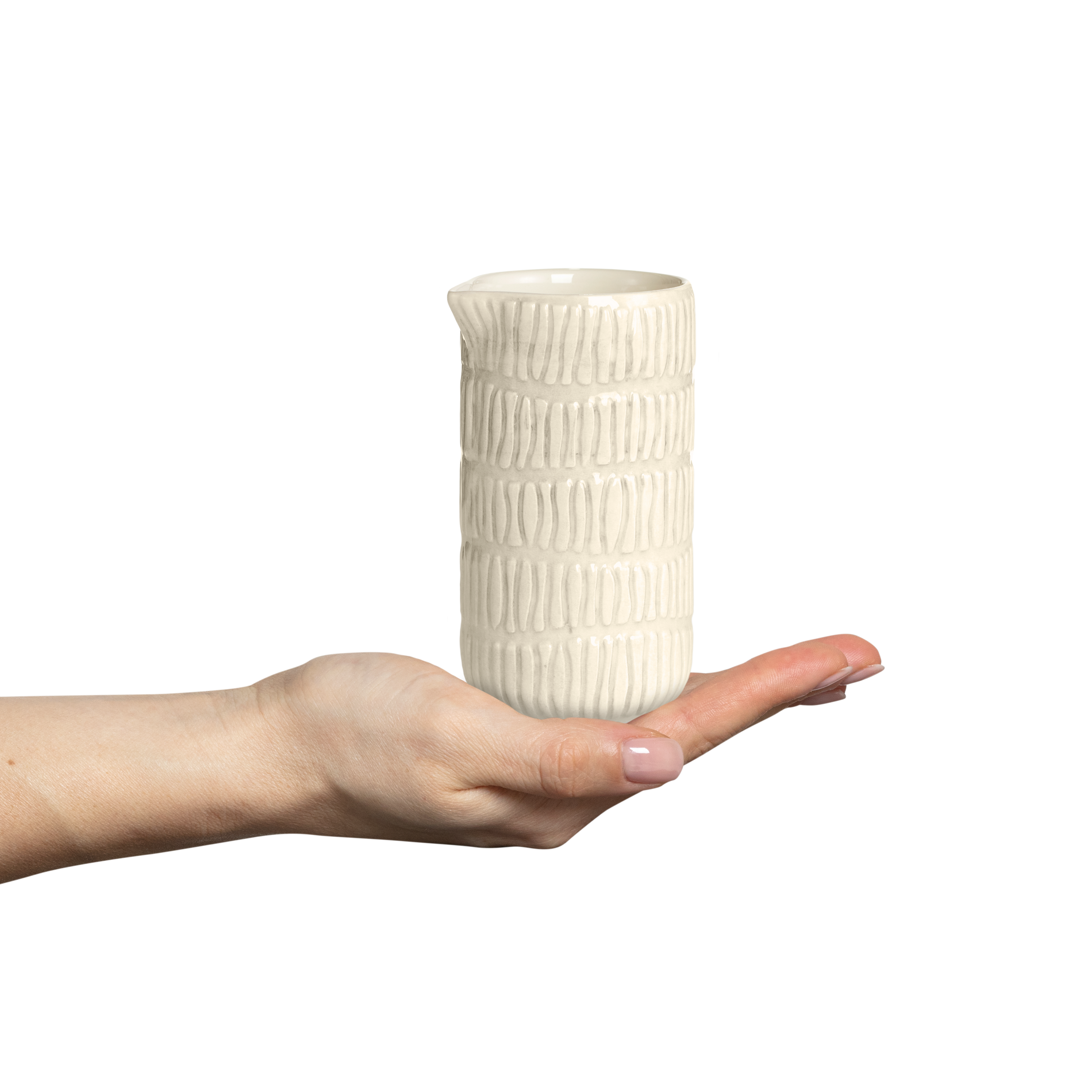 Hand holding a textured ceramic jug against a white background