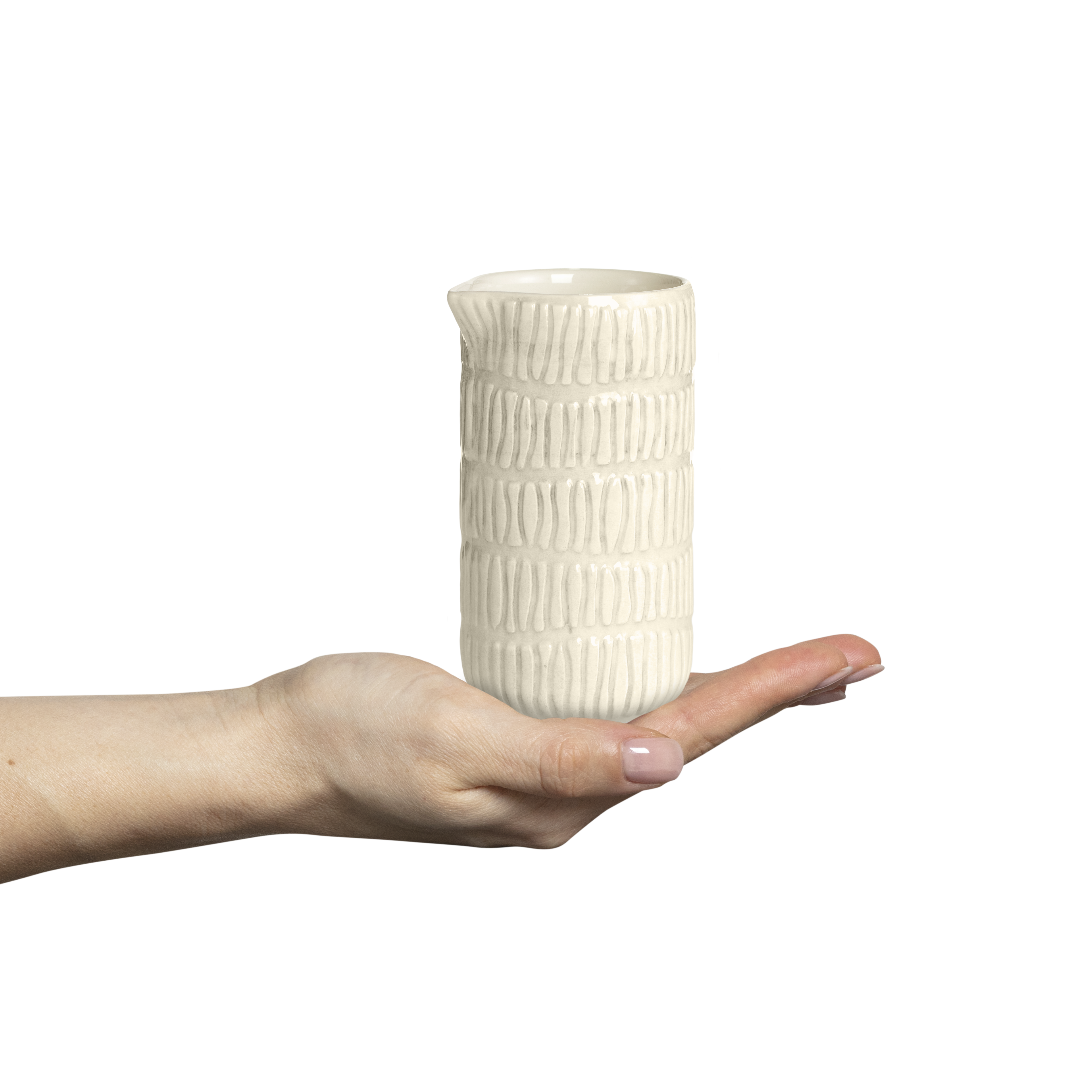 Hand holding a textured ceramic jug against a white background