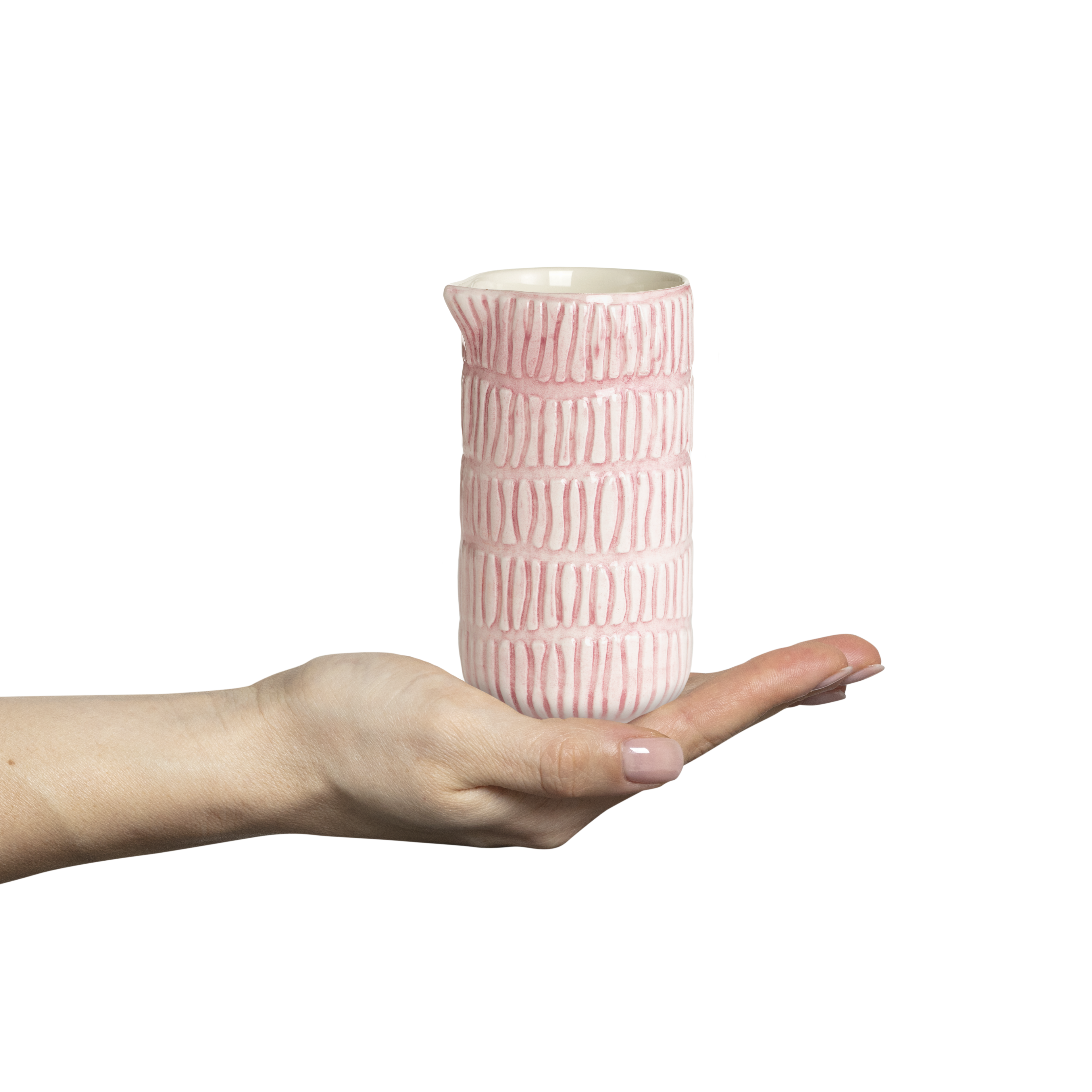 Pink textured ceramic jug held in a hand against a white background