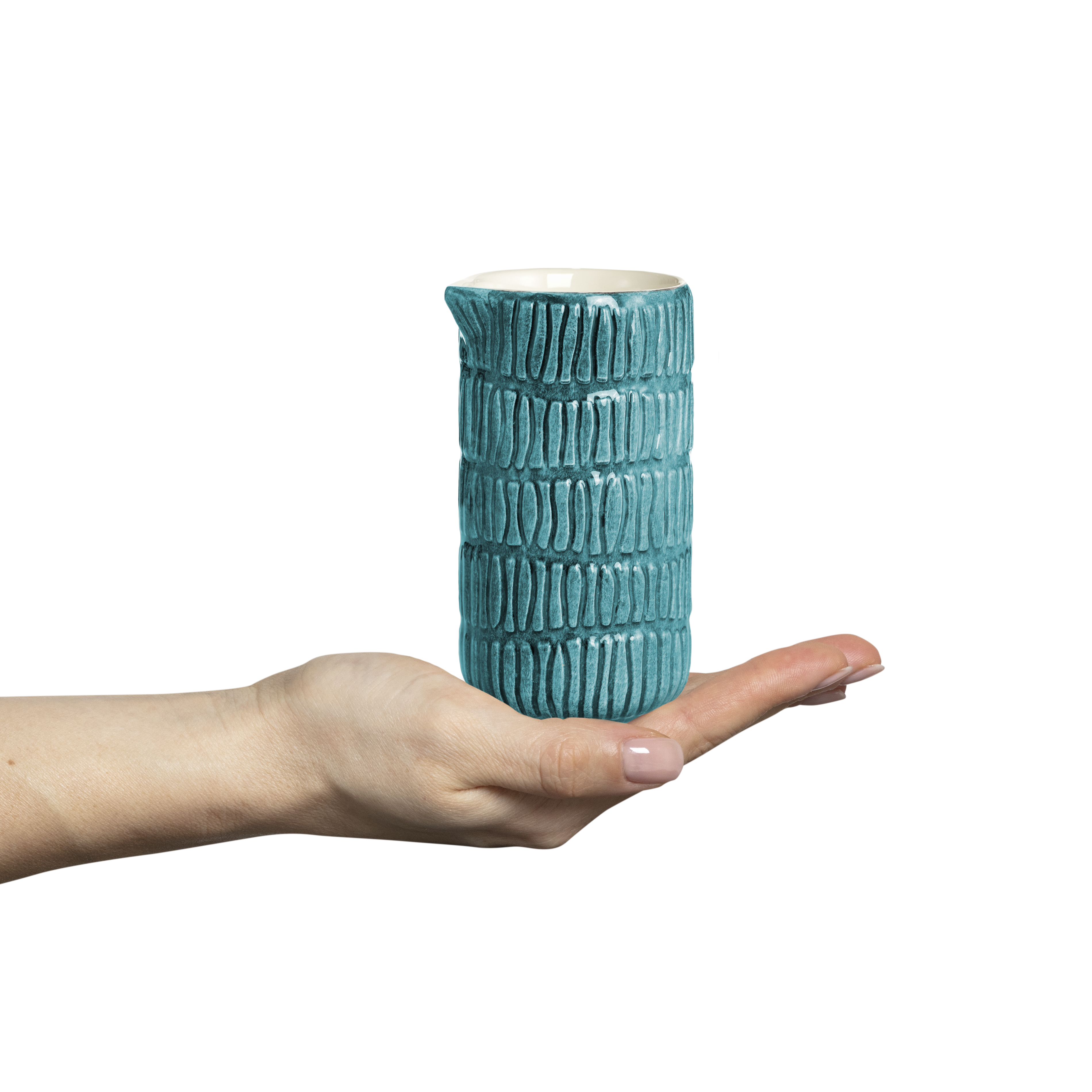 Ceramic jug held in a hand against a white background