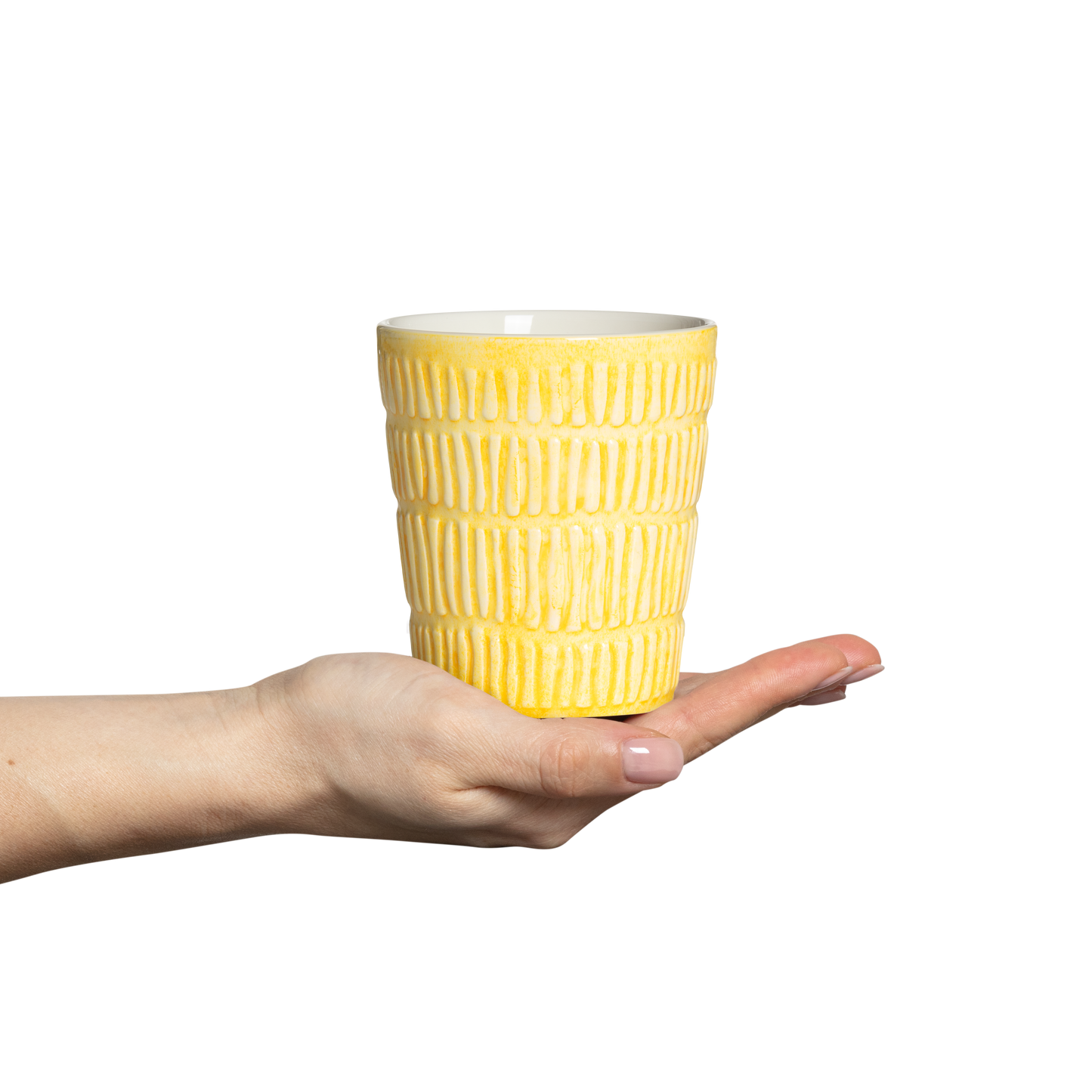 Yellow textured mug held in a hand against a white background