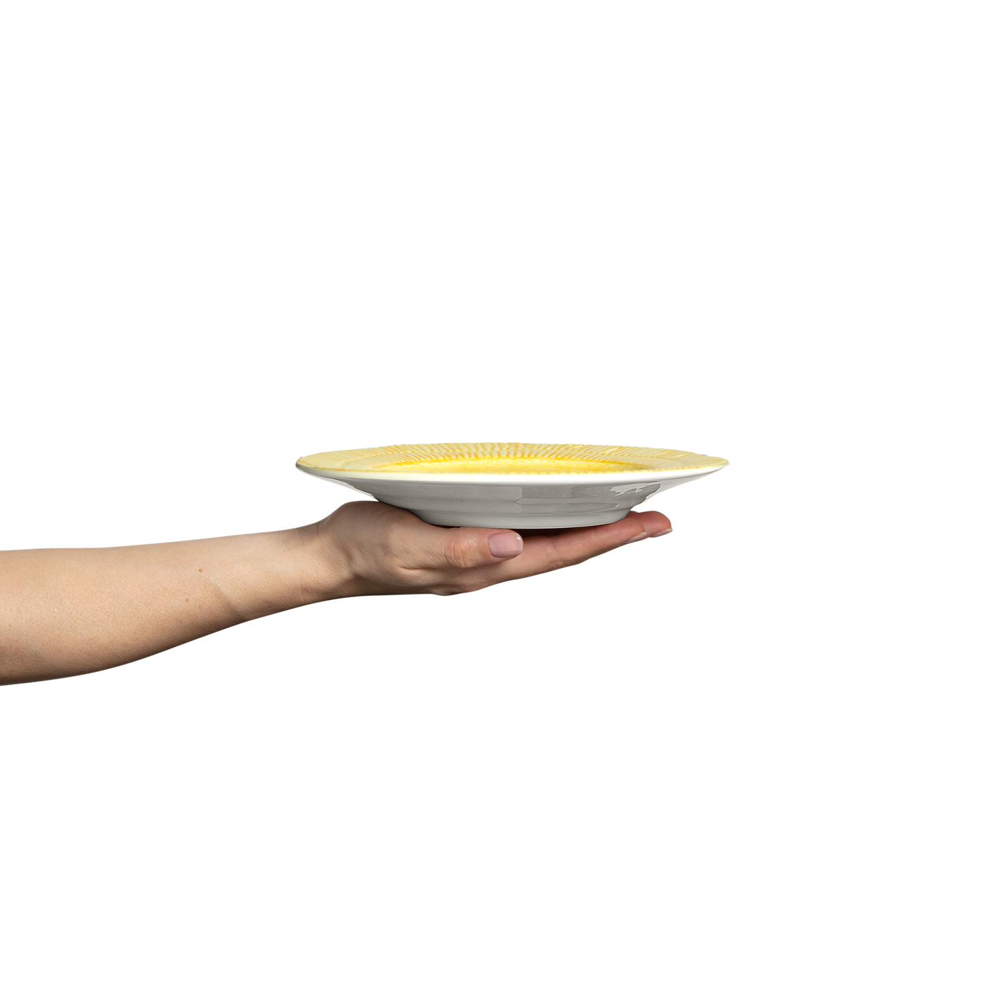 Hand holding a yellow and white ceramic plate against a white background