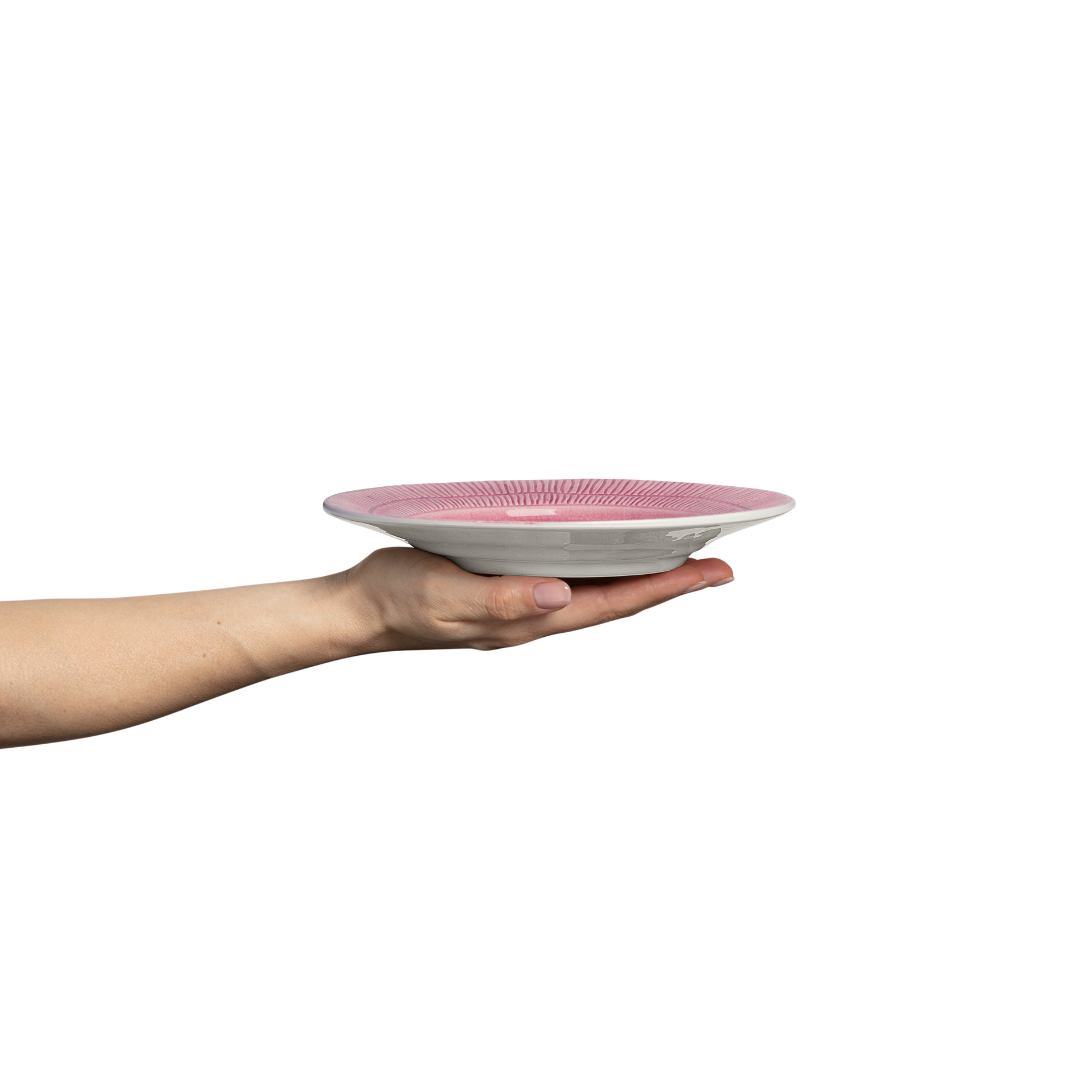 Hand holding a pink and white ceramic plate against a white background