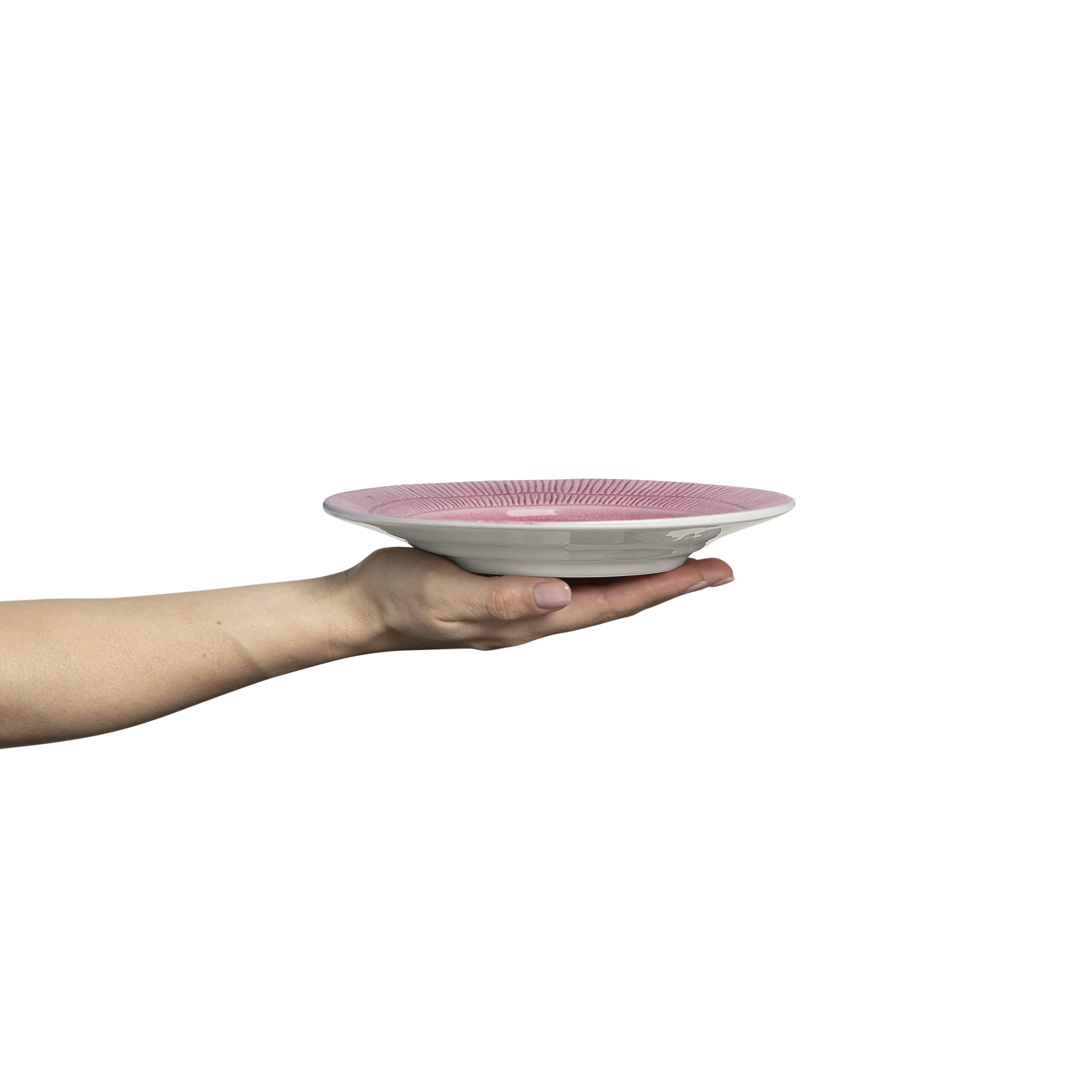 Hand holding a pink and white ceramic plate against a white background