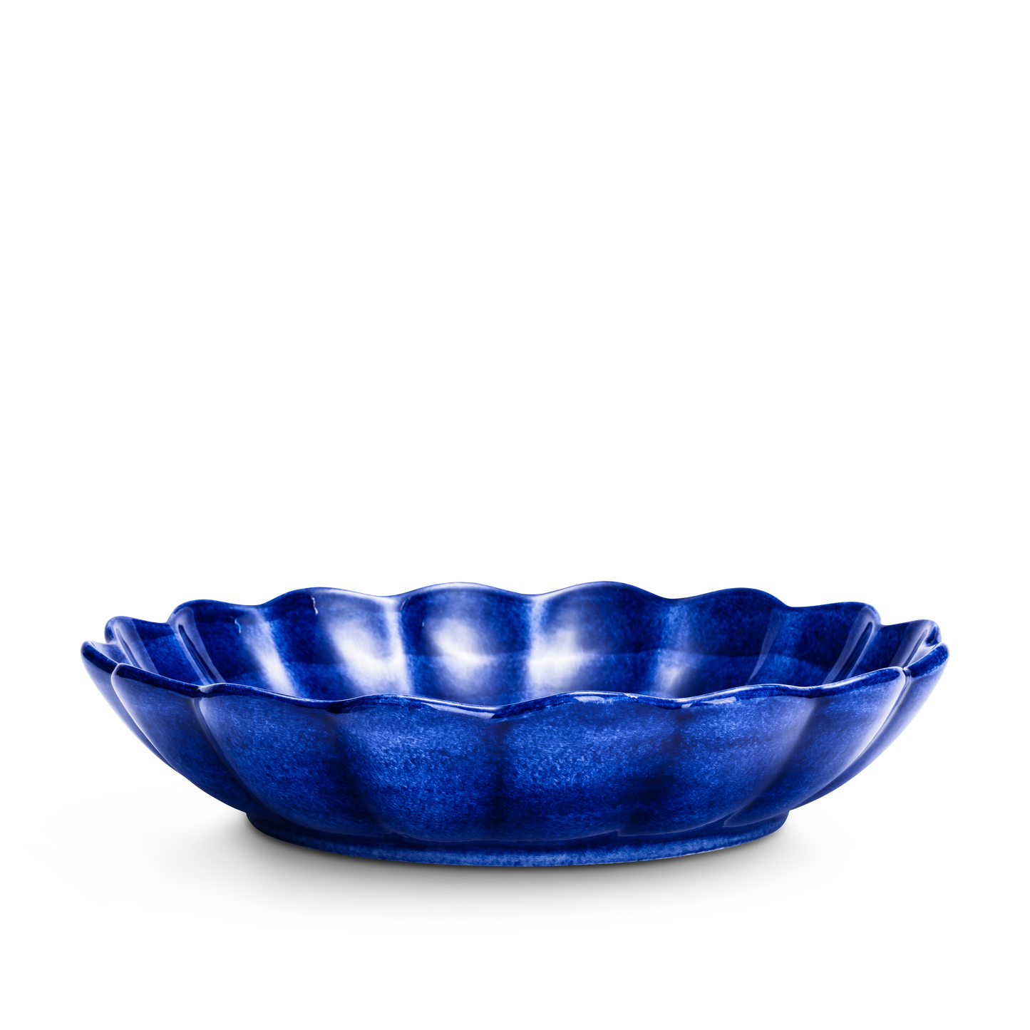 Blue ceramic dish with scalloped edge on a white background