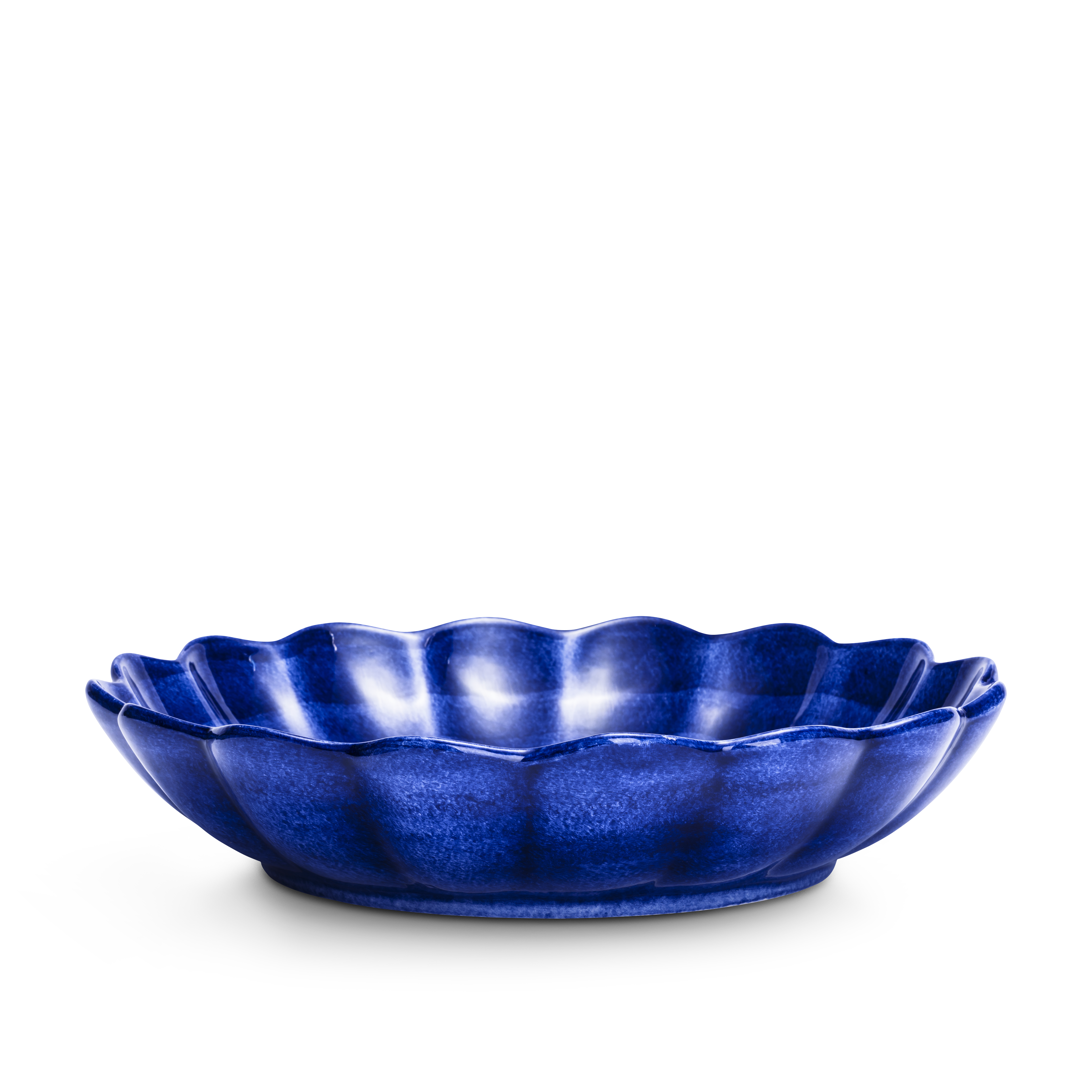 Blue ceramic dish with scalloped edge on a white background