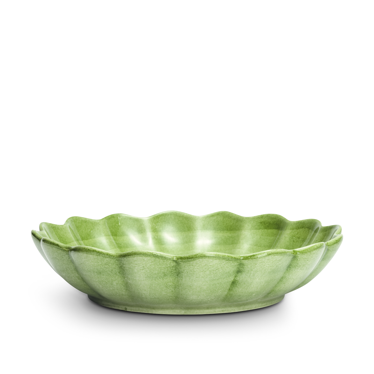 Green ceramic bowl with scalloped edge on a white background