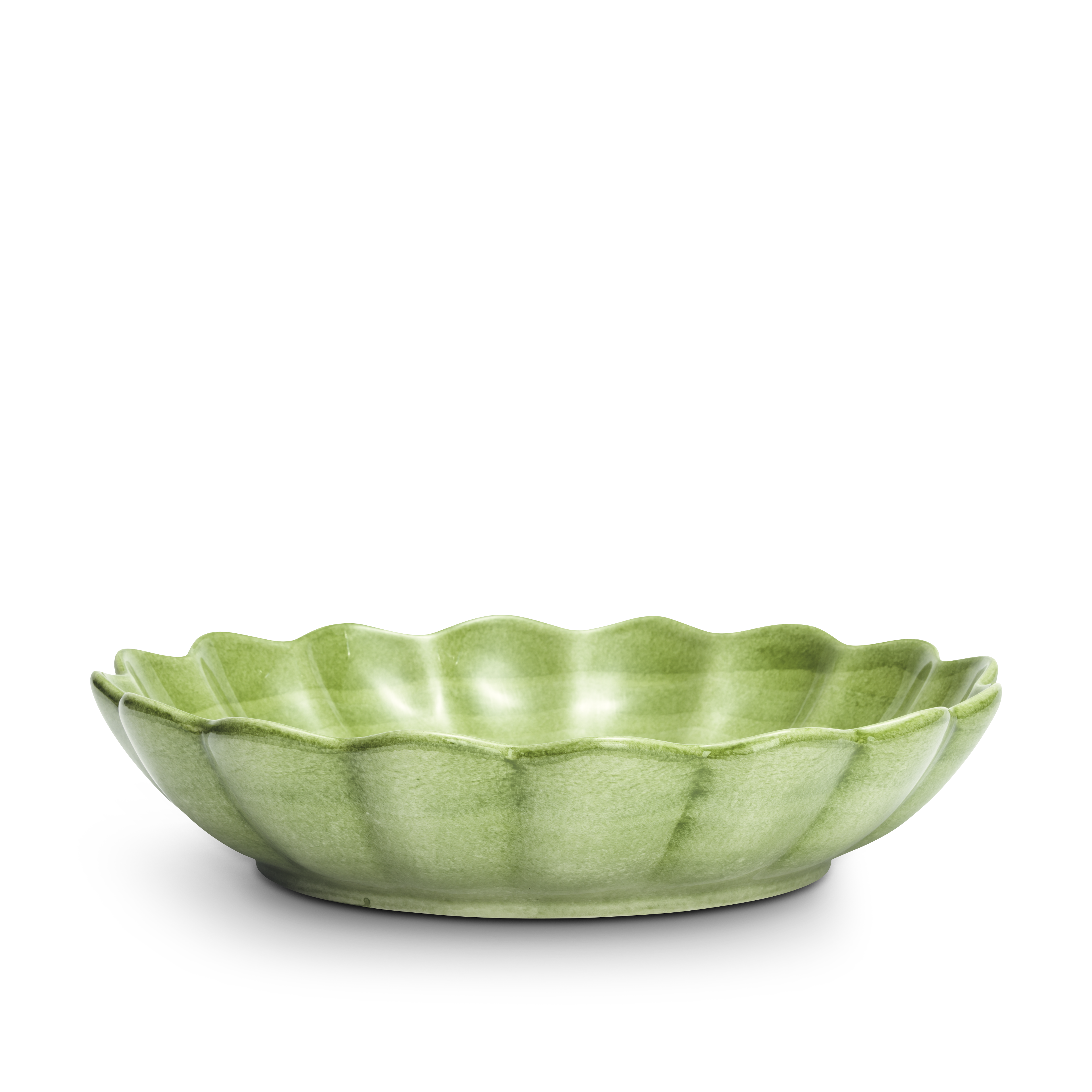 Green ceramic bowl with scalloped edge on a white background