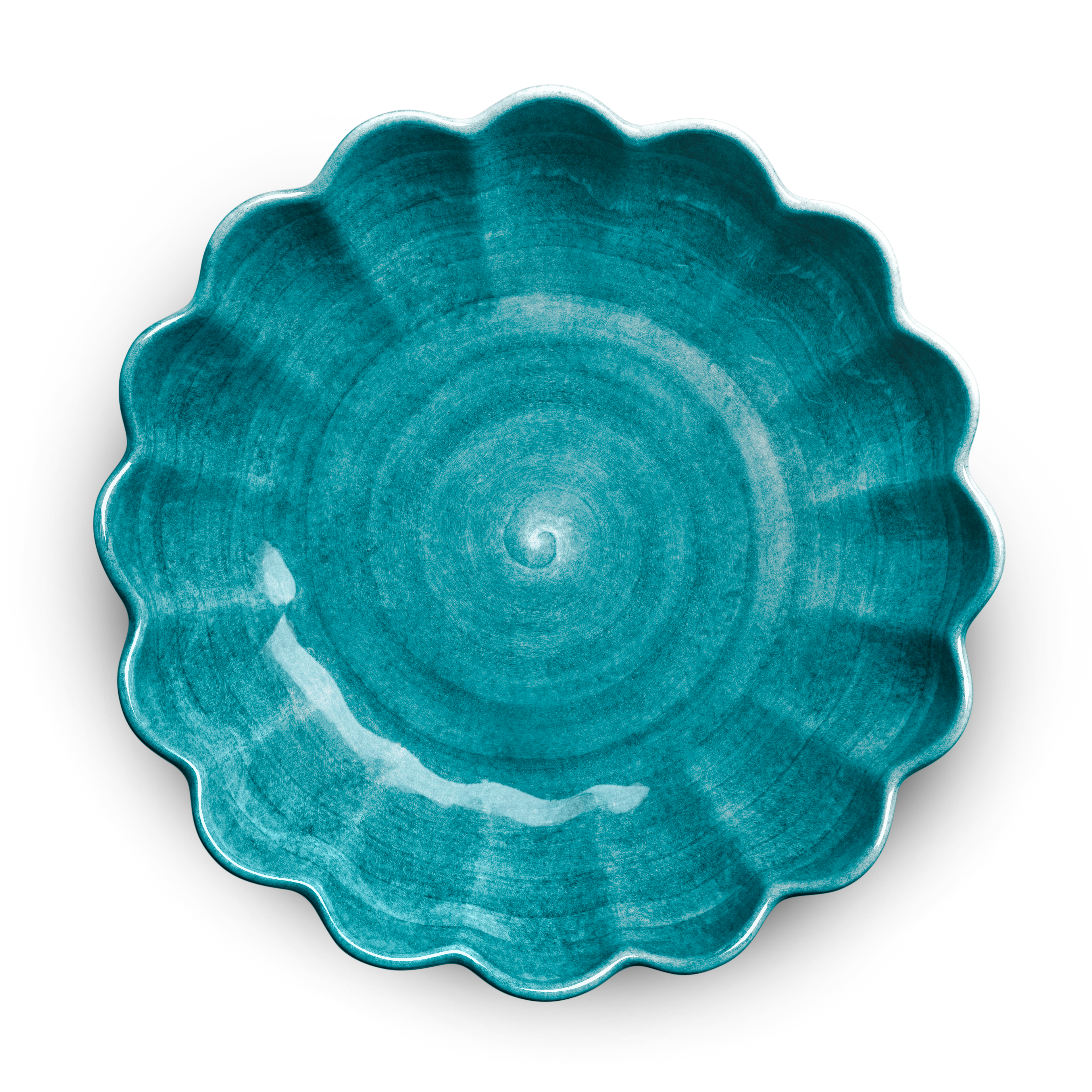 Teal ceramic plate with scalloped edge on a white background